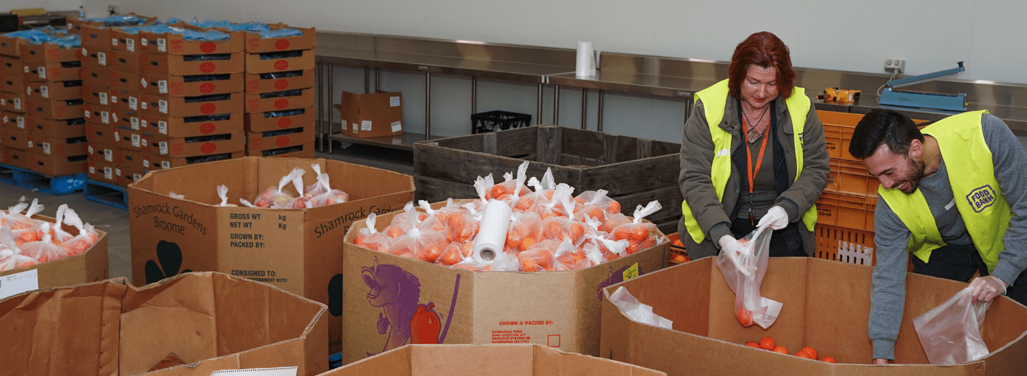 Foodbank volunteers packing food in a warehouse